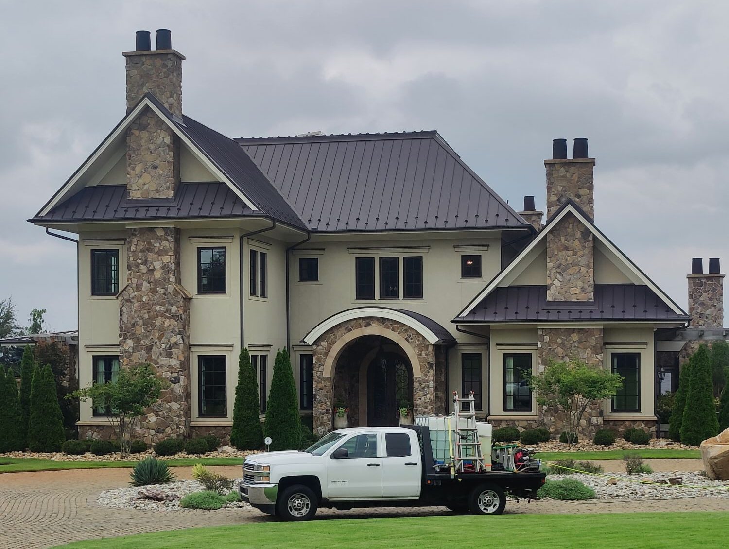 The Soda City truck in front of a large stone and stucco lake house after a house wash